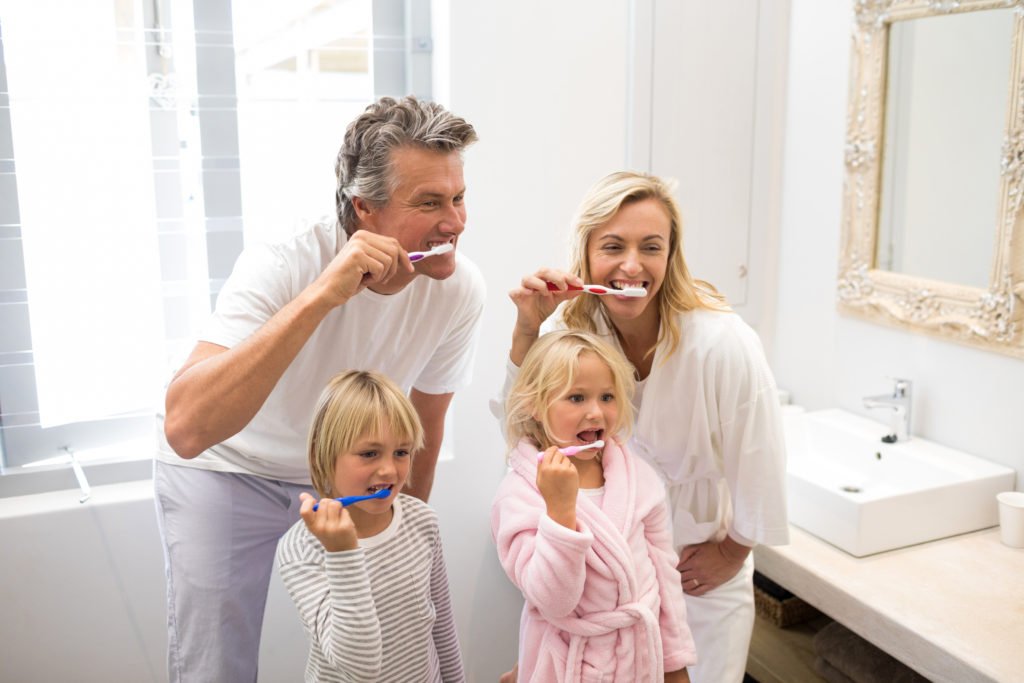 A family of four, brushing their teeth